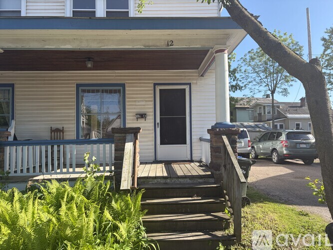 A small white house with a wooden deck in front.