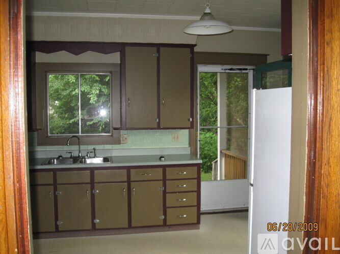 A kitchen with brown cabinets and a white refrigerator.