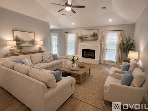 A living room with a beige couch, a coffee table, and a fireplace.