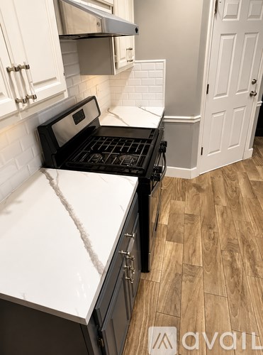 A kitchen with a black oven and white cabinets.