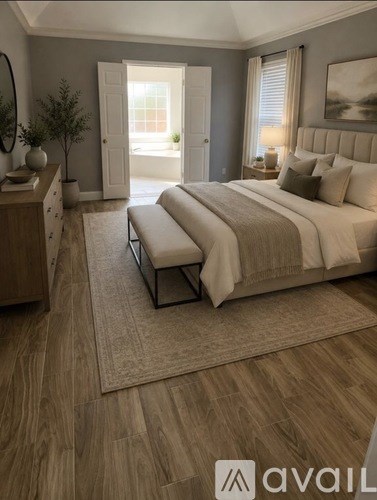A bedroom with a large bed and a bench in front of it.