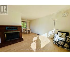A bedroom with a bed, a chair, and a fireplace.