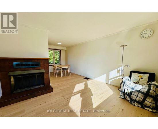 A bedroom with a bed, a chair, and a fireplace.