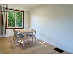 A dining room with a table and chairs.