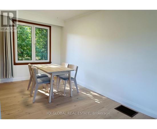 A dining room with a table and chairs.