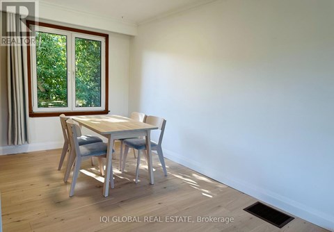 A dining room with a table and chairs.