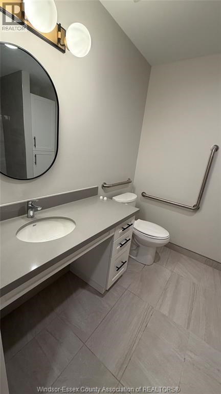 A bathroom with a sink, toilet, and mirror.