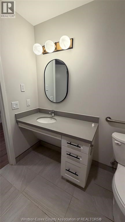 A bathroom with a sink, mirror, and toilet.