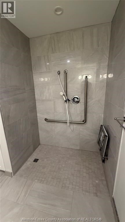 A shower area with a glass door and a glass shower head.