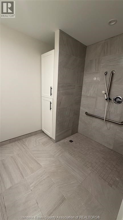 A bathroom with a walk in shower and a white door.
