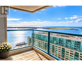 A balcony with a view of a body of water and buildings.