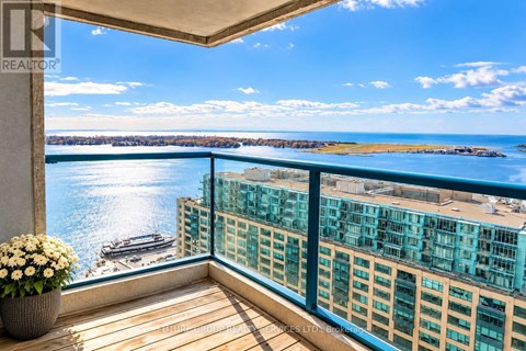 A balcony with a view of a body of water and buildings.