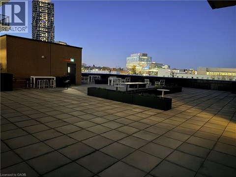 A rooftop with a tiled floor and a building in the background.
