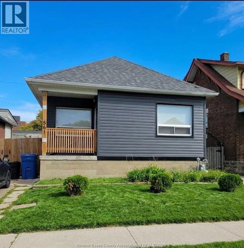 A house with a grey siding and a brown wooden fence.