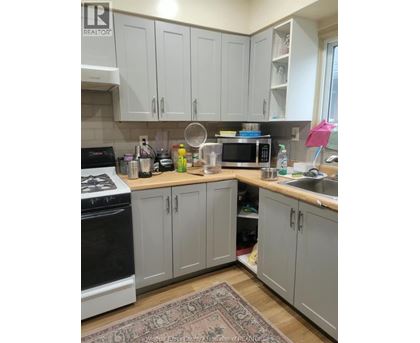 A kitchen with a black stove top oven and white cabinets.