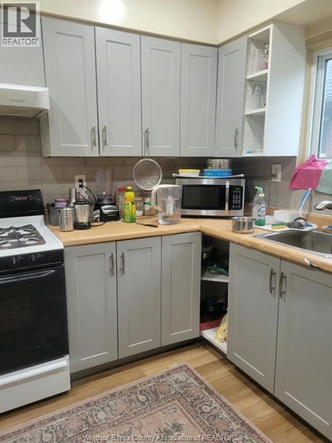 A kitchen with a black stove top oven and white cabinets.