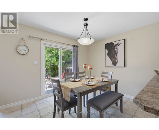 A dining room with a table set for two and a clock on the wall.