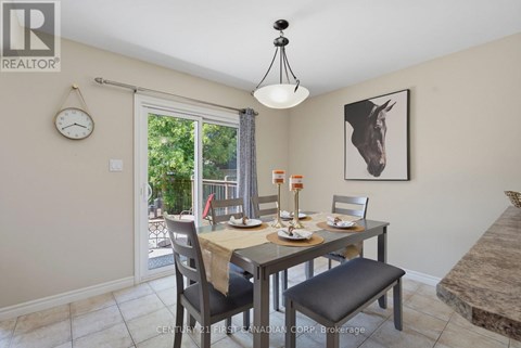 A dining room with a table set for two and a clock on the wall.