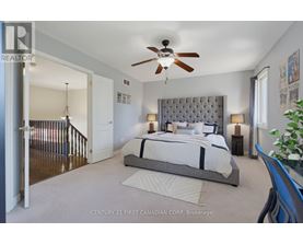 A bedroom with a large bed and a ceiling fan.