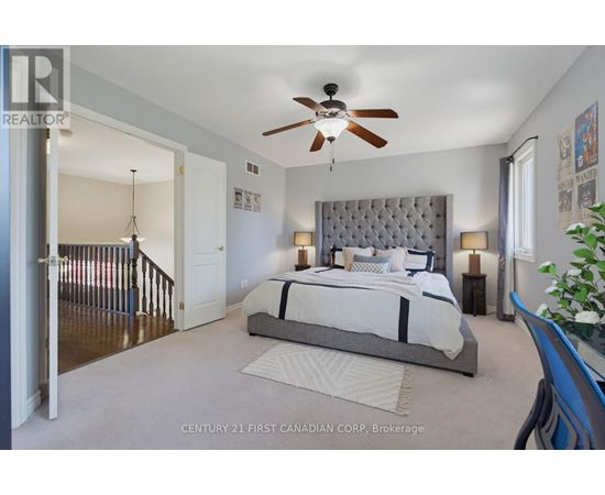 A bedroom with a large bed and a ceiling fan.
