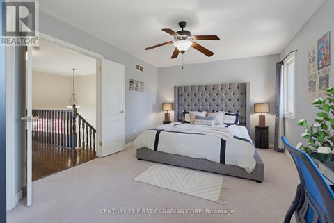 A bedroom with a large bed and a ceiling fan.