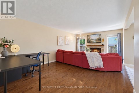 A living room with a red couch and a fireplace.