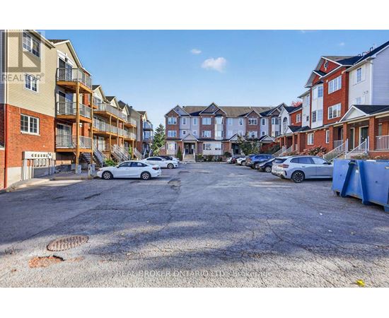 A parking lot with cars and apartment buildings in the background.