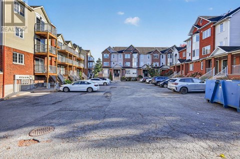 A parking lot with cars and apartment buildings in the background.