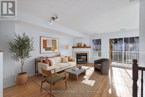 A living room with a couch, chair, and a potted plant.