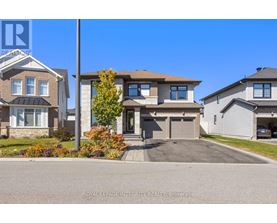 A house with a grey roof and a white garage door is for sale.
