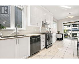 A kitchen with white cabinets and a marble countertop.
