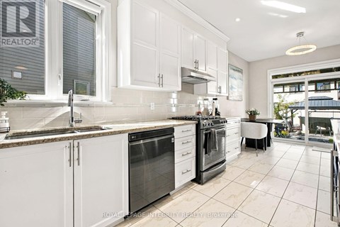 A kitchen with white cabinets and a marble countertop.