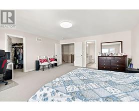 A bedroom with a large bed and a dresser.