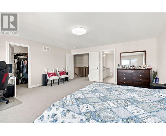 A bedroom with a large bed and a dresser.