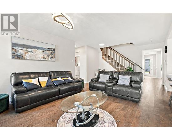 A living room with a leather couch and a glass coffee table.