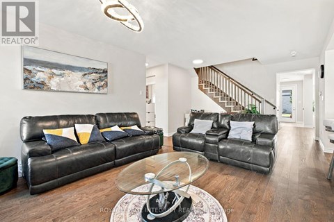 A living room with a leather couch and a glass coffee table.