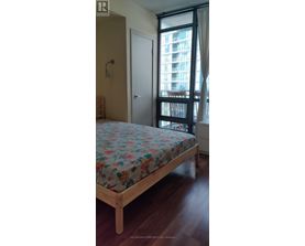 A bedroom with a large bed and a window overlooking a building.