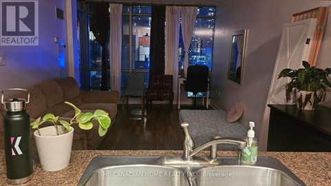 A kitchen with a sink and a window with a view of the city.