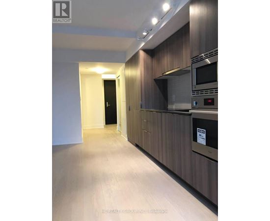 A modern kitchen with dark wood cabinets and stainless steel appliances.