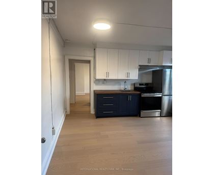 A kitchen with white cabinets and a wooden island.