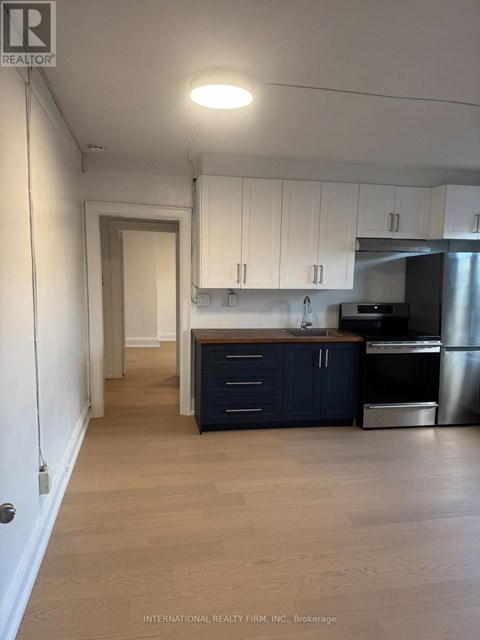 A kitchen with white cabinets and a wooden island.