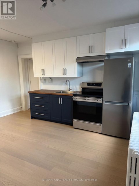A kitchen with white cabinets and a stainless steel refrigerator.
