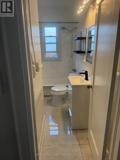 A white toilet in a small bathroom with a shower.