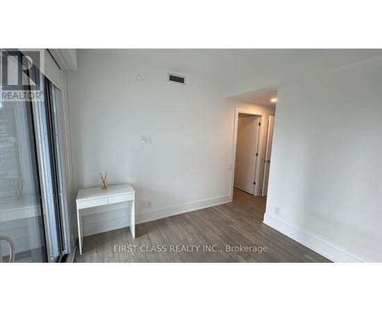 A room with a white bench and a door in the background.