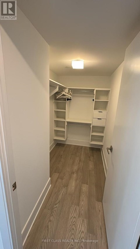 A hallway with a staircase and a light on the ceiling.