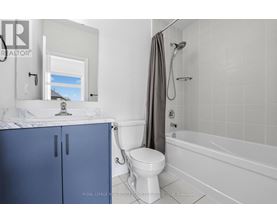 A white bathroom with a blue cabinet and a white toilet.