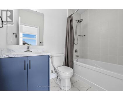 A white bathroom with a blue cabinet and a white toilet.