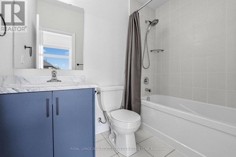 A white bathroom with a blue cabinet and a white toilet.
