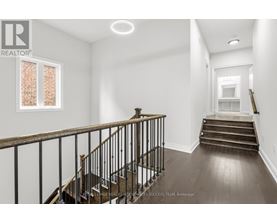 A spacious room with a staircase leading to the second floor.