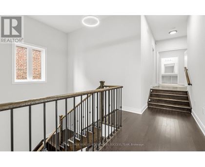 A spacious room with a staircase leading to the second floor.